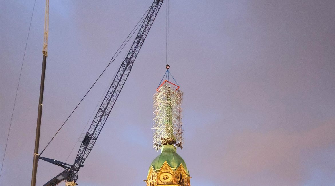 Am Kran gesichertes Stützgerüst auf der Turmspitze